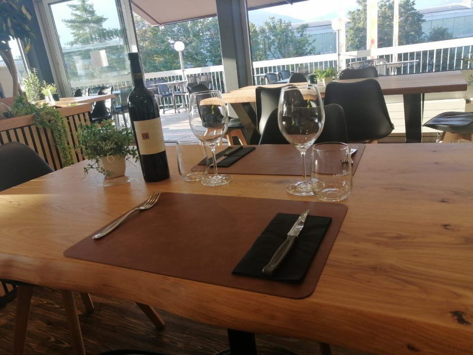 Une bouteille de vin est posée sur une table en bois dans un restaurant