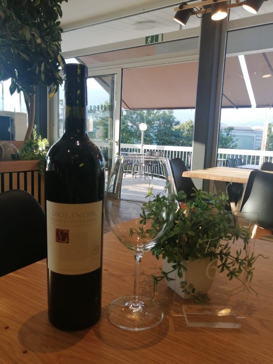 Une bouteille de vin est posée sur une table à côté d'un verre