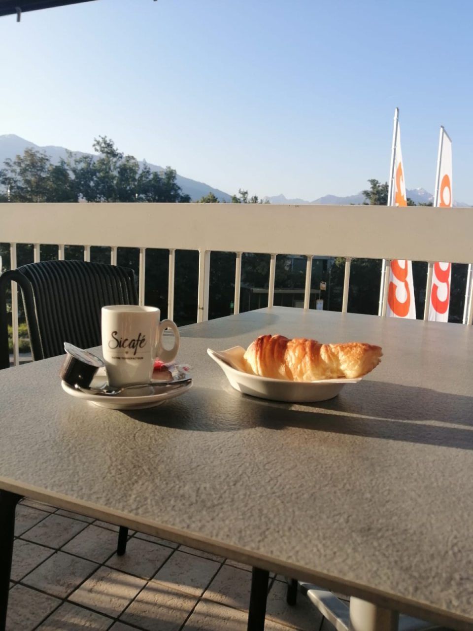 Une tasse de café est posée sur une table à côté d'une assiette de nourriture