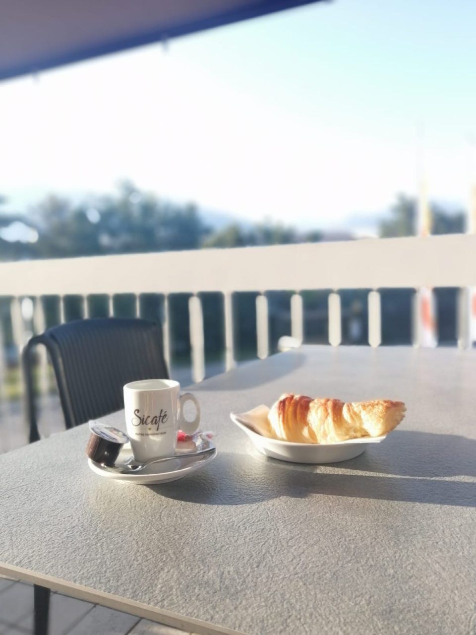 Une table avec une tasse de café et un croissant dessus