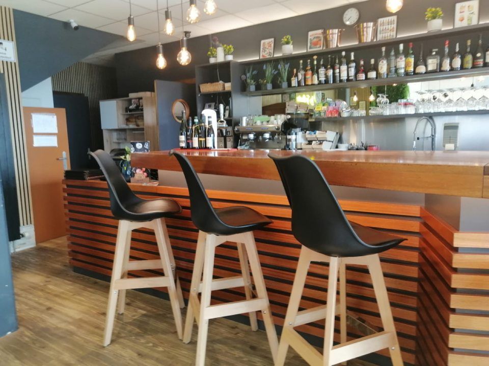 Trois tabourets de bar sont alignés devant un bar dans un restaurant.