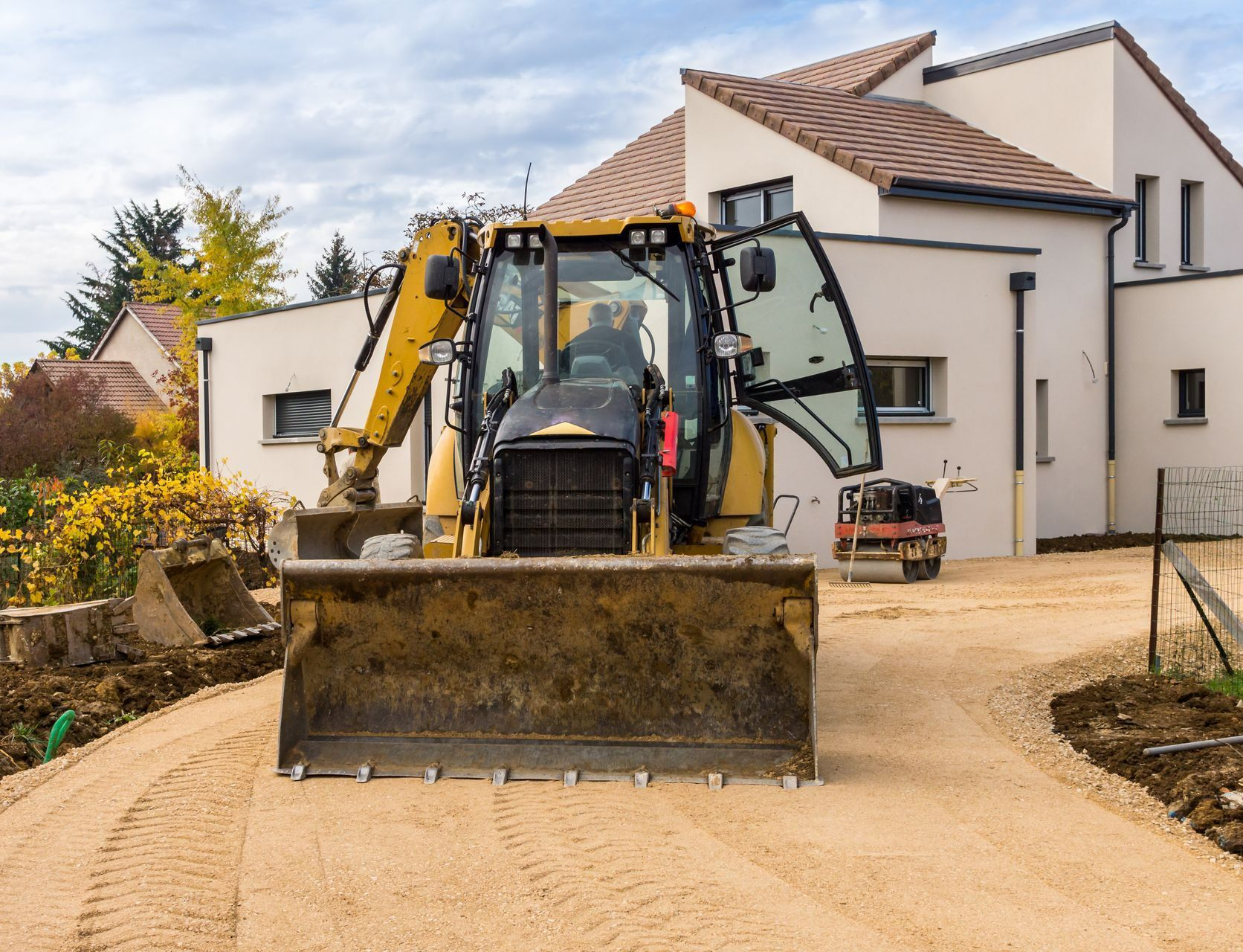 Une maison avec un engin de chantier devant