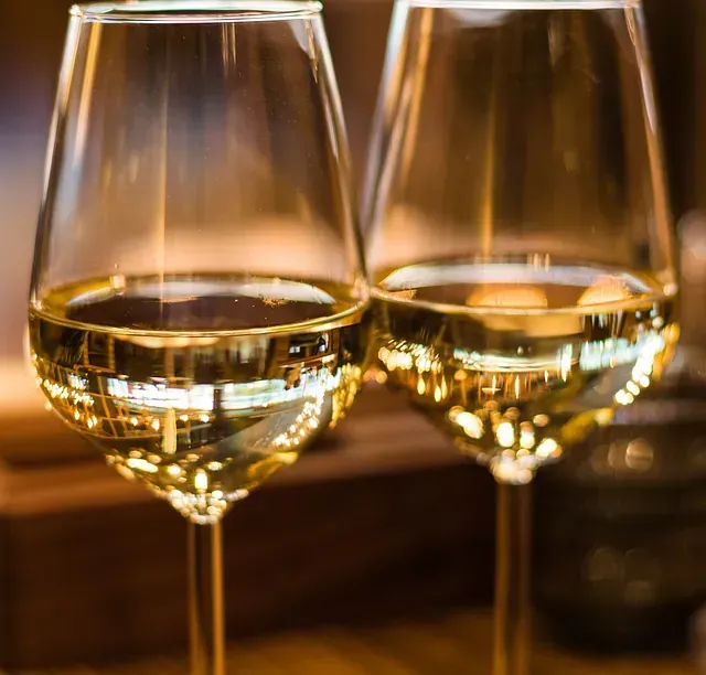 Dos copas de vino están sentadas una al lado de la otra en una mesa.