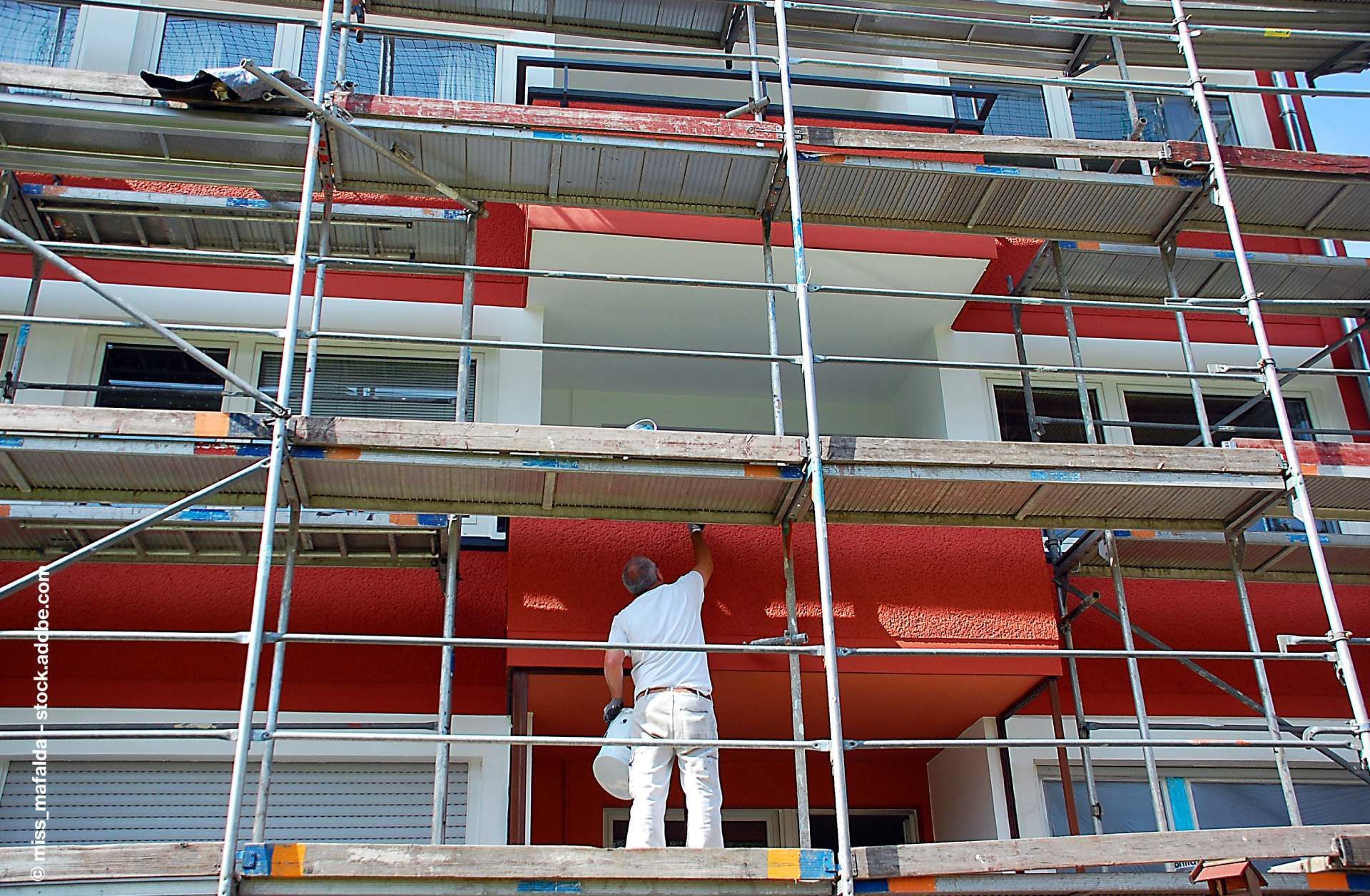 Außenarbeiten: Maler streicht die Fassade eines Hauses
