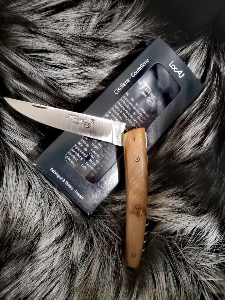 Couteau artisanal, posé sur sa boîte d'emballage et une fourrure en arrière-plan