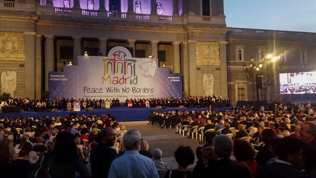 Al anochecer, una multitud se congregó en un escenario de conciertos al aire libre iluminado con una gran pancarta