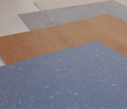 Cuatro muestras de suelos en diferentes colores y texturas: blanco, gris, veta de madera y moteado azul.