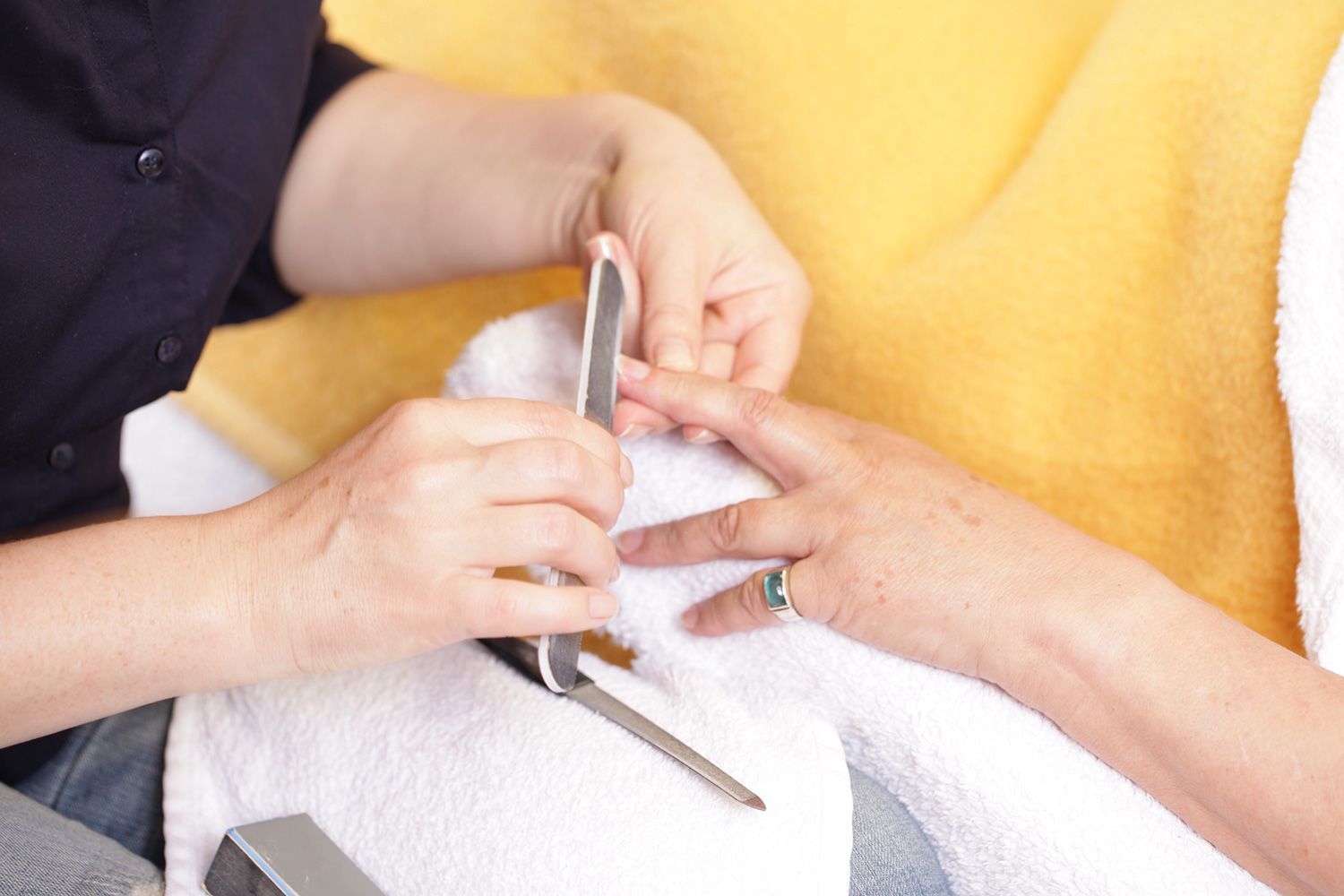 Eine Frau lässt sich in einem Nagelstudio die Nägel machen