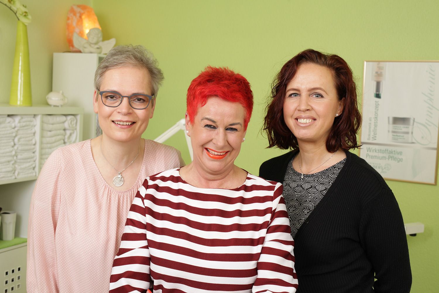 Drei Frauen posieren zusammen in einem Raum für ein Foto.