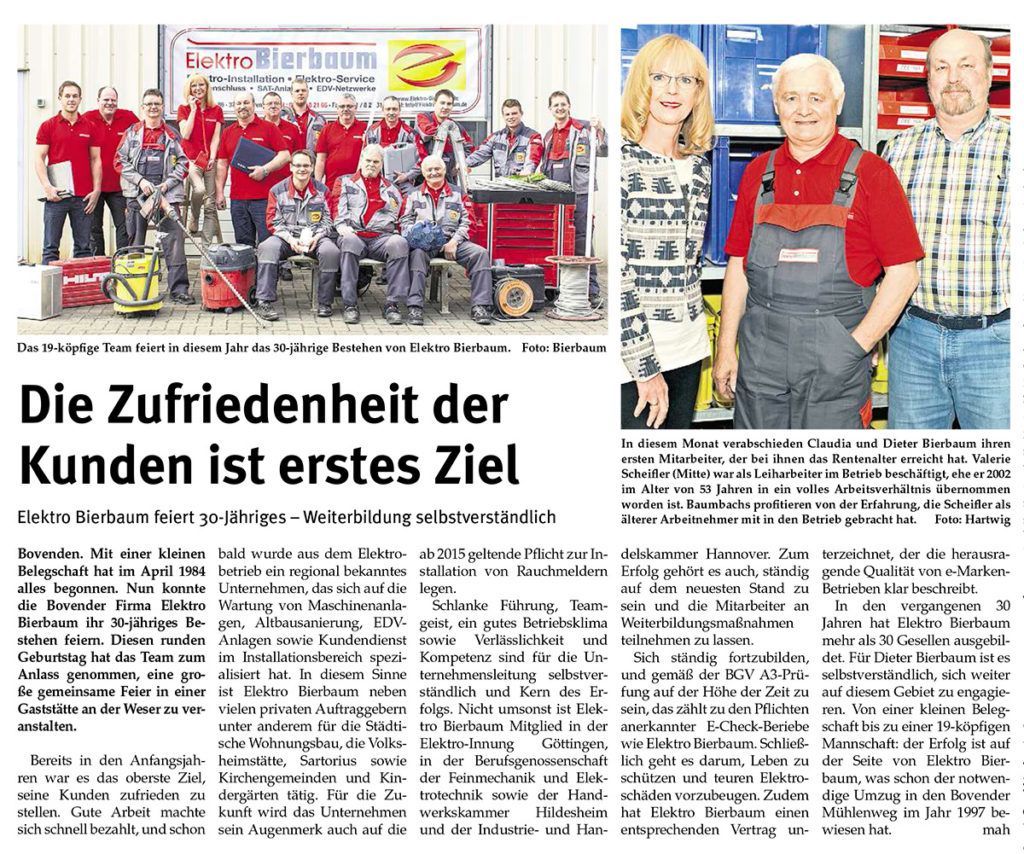 Eine Gruppe von Menschen posiert für ein Foto in einer Zeitung.