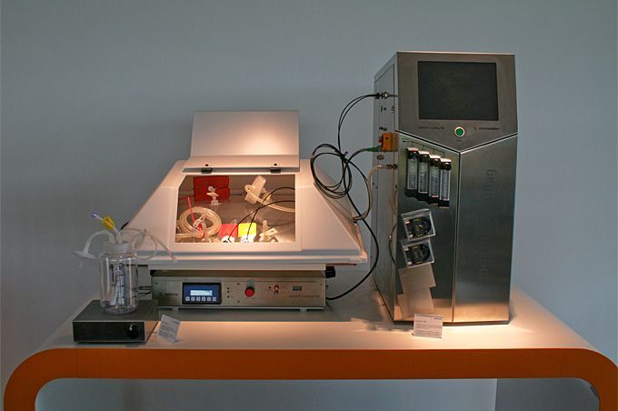 Eine Maschine steht auf einem Tisch neben einem Monitor