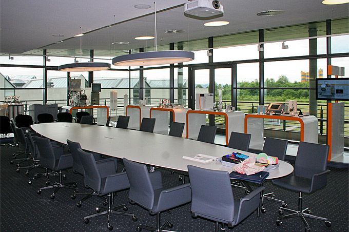 Ein Konferenzraum mit einem langen Tisch und Stühlen