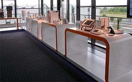 Eine lange Reihe weißer Tische mit orangefarbenem Rand