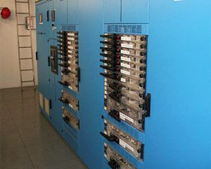 Eine Reihe blauer Schaltschränke in einem Raum mit einer Leiter.