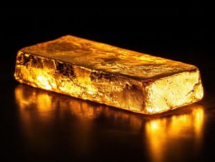 Lingot d'or brillant sur une surface sombre et réfléchissante