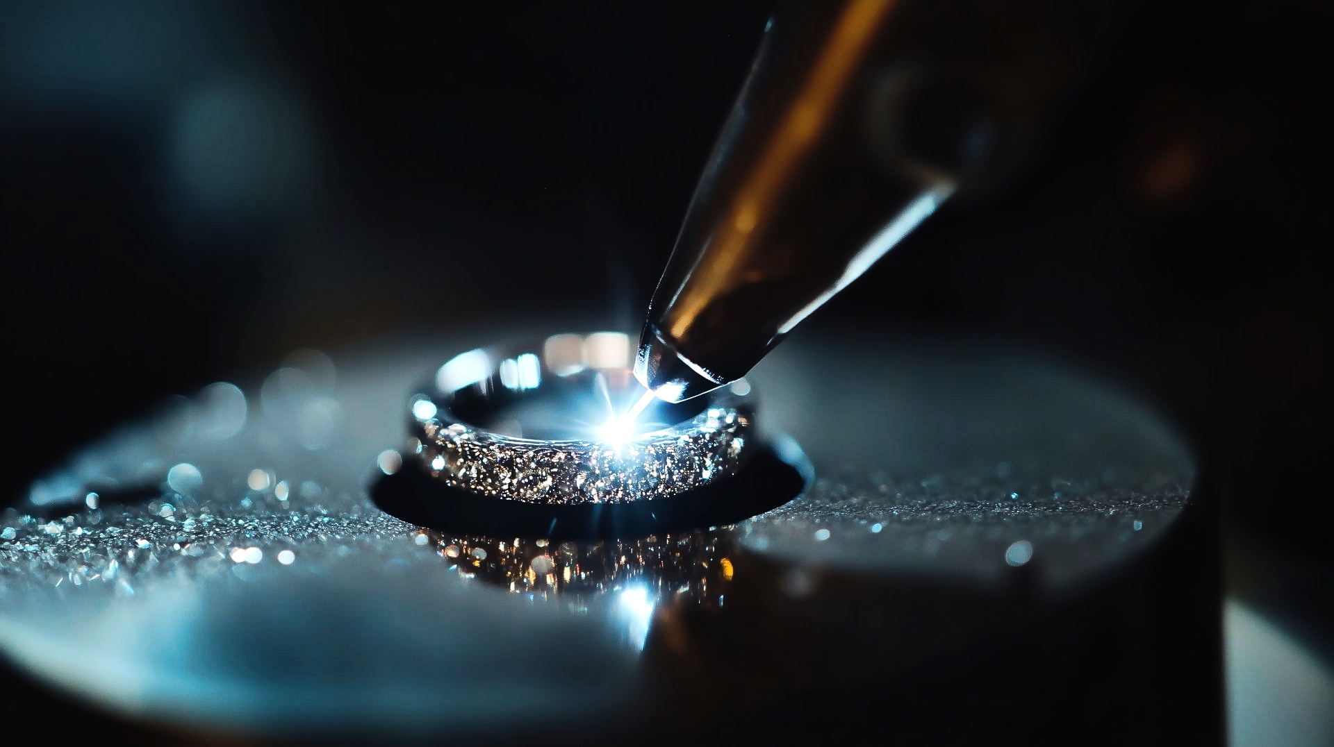 Gros plan sur laser plaçant gravant un anneau métallique dans un atelier.
