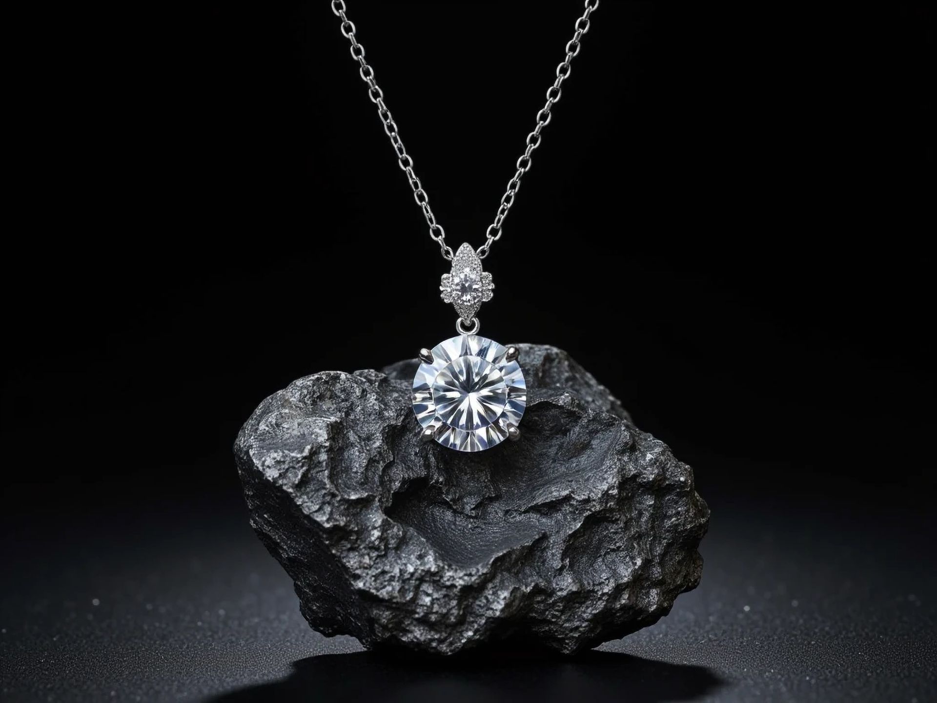 Collier de diamants présenté sur une roche noire brute, sur fond sombre.