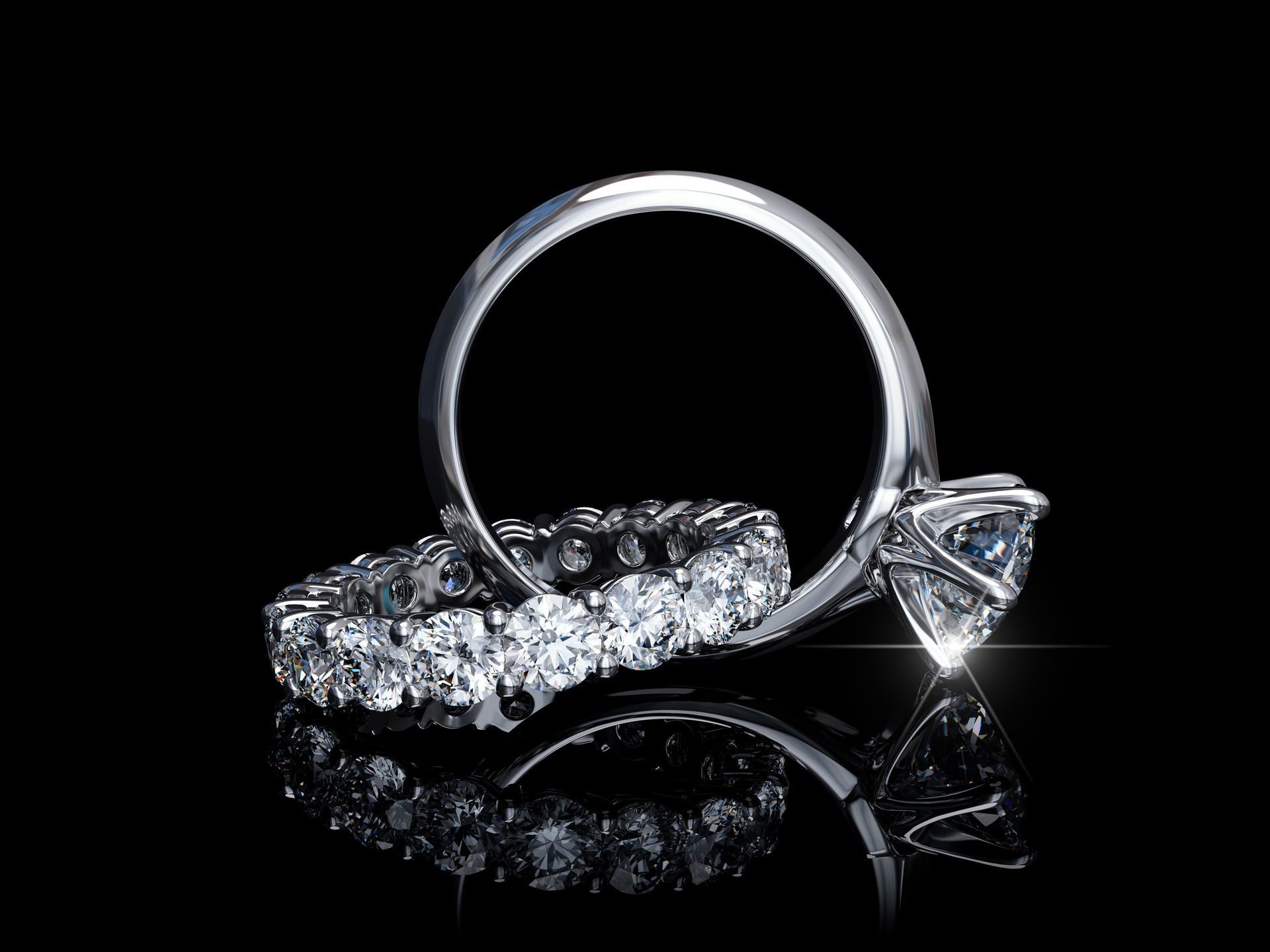 Bague de fiançailles en diamant sur fond noir, avec une grosse pierre centrale ronde et un anneau étincelant.