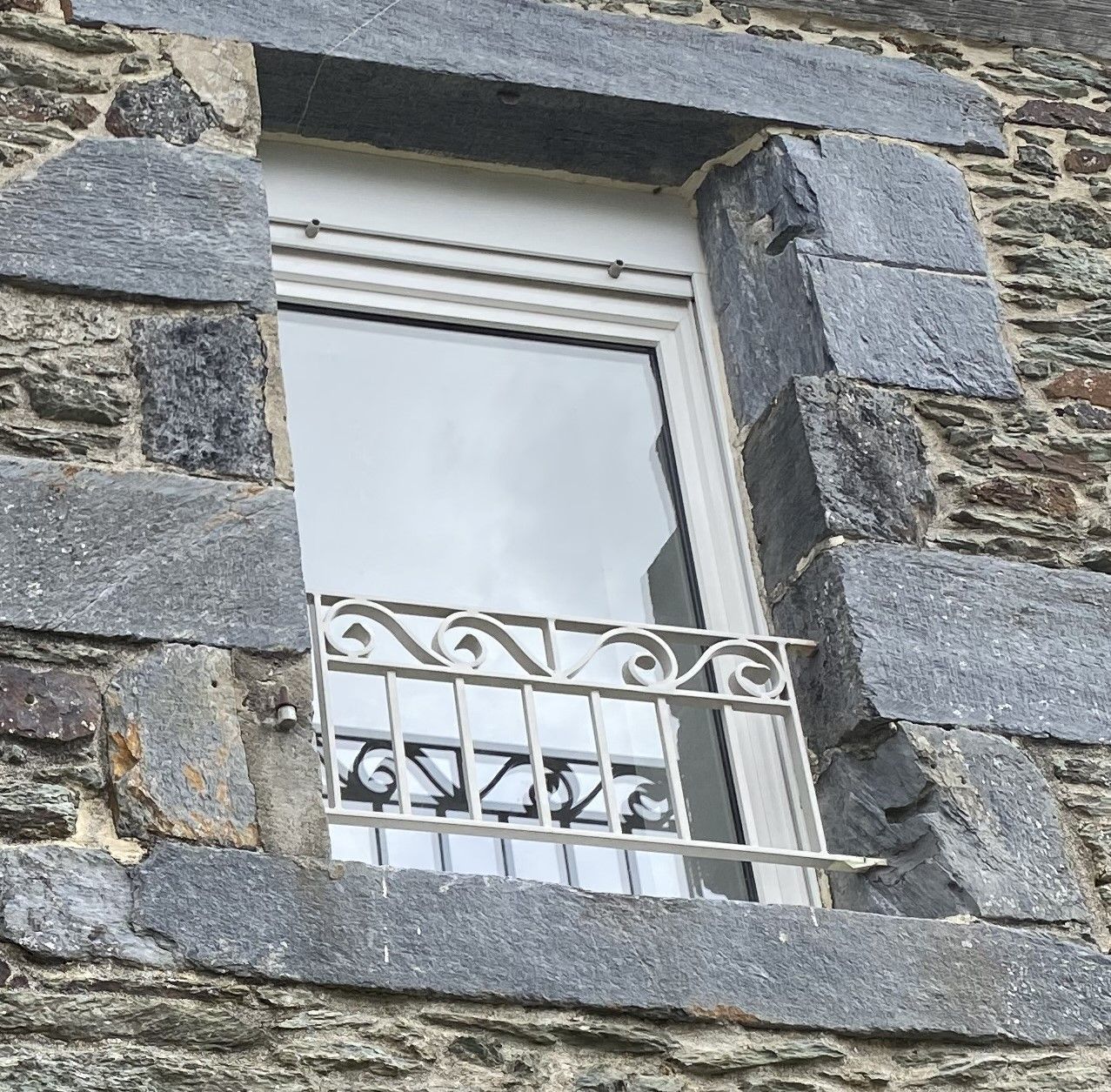 Un appuis de fenêtre en fer forgé et peint en blanc