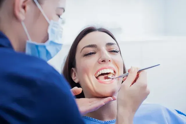 Una mujer está siendo examinada por un dentista.