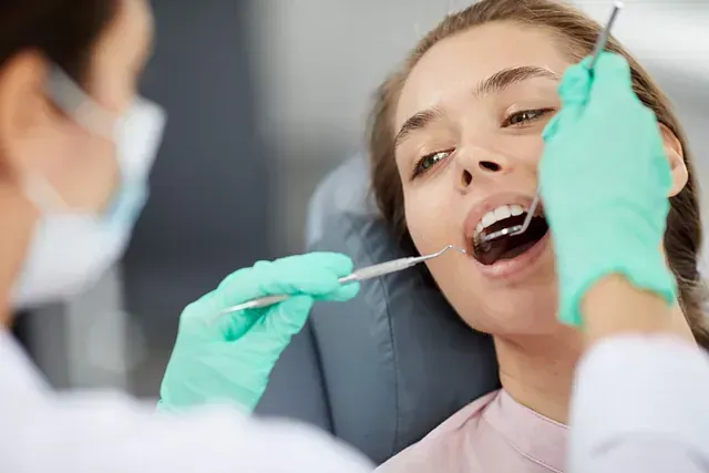 Una mujer está siendo examinada por un dentista.