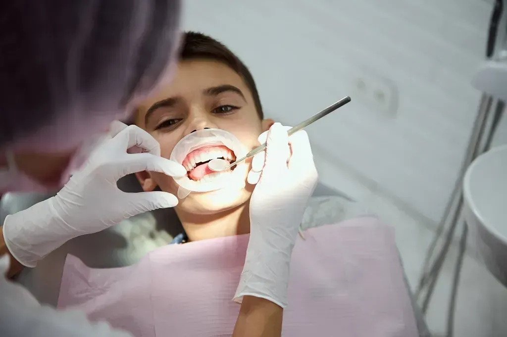Un niño pequeño está siendo examinado por un dentista.