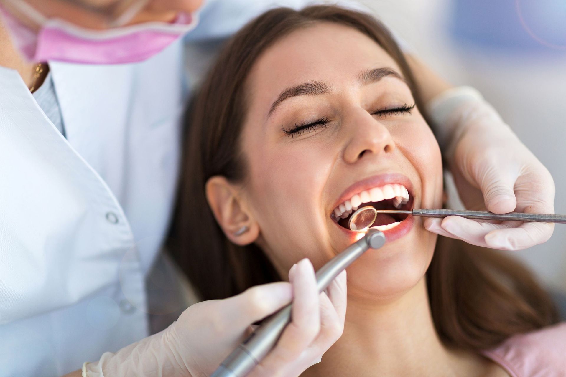Una mujer está siendo examinada por un dentista.