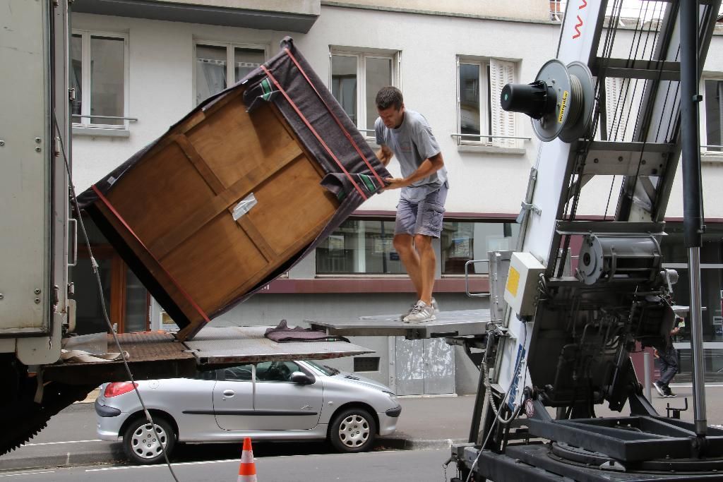 Déménageur qui charge du mobilier dans un  camion