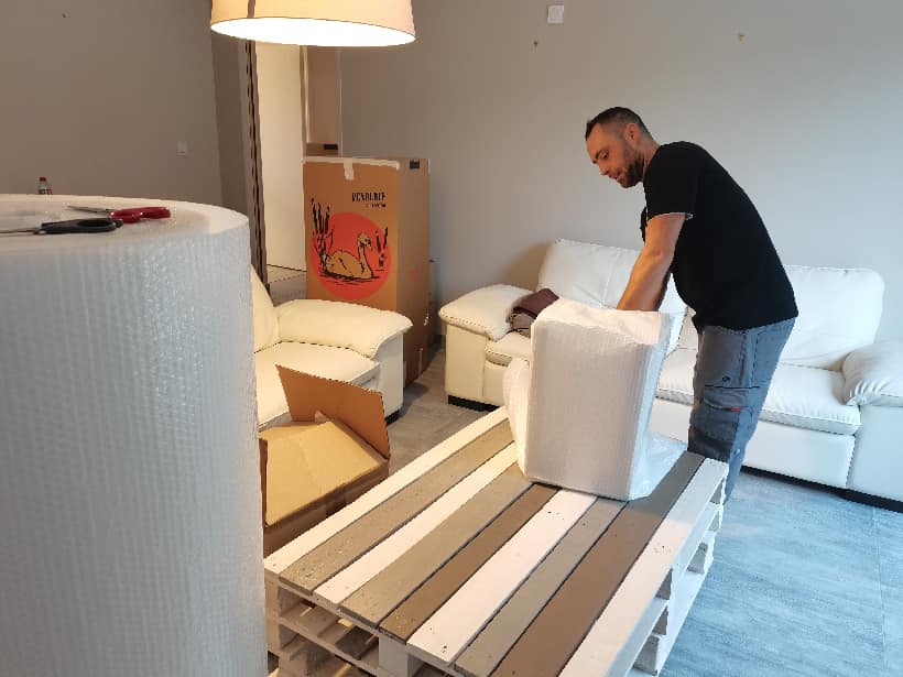 Déménageur qui emballe un objet avec du papier bulle