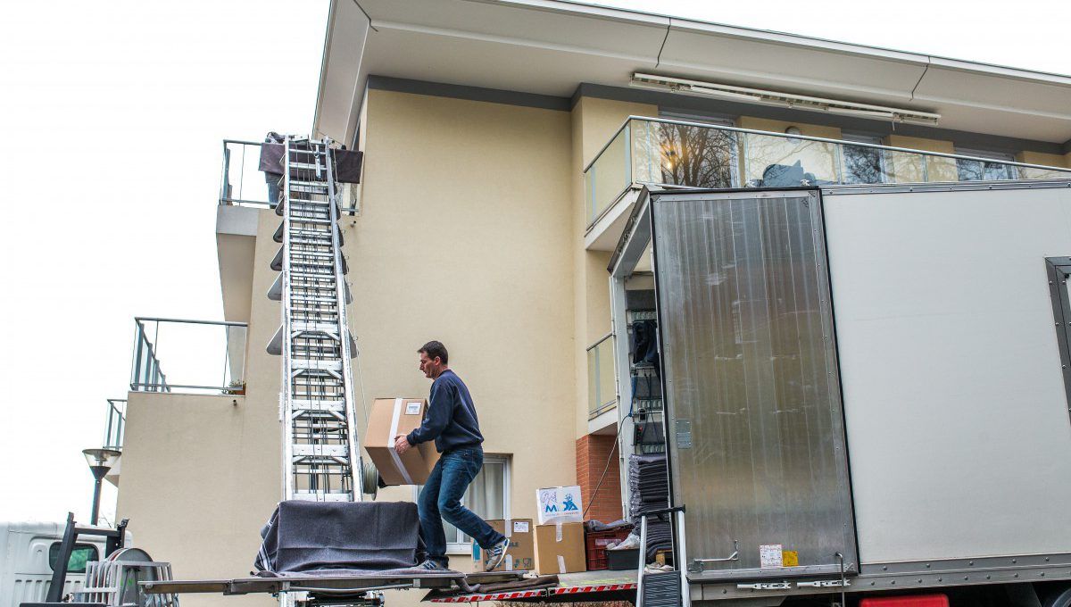 Déménageur qui réceptionne un carton à l'aide d'un monte-charges