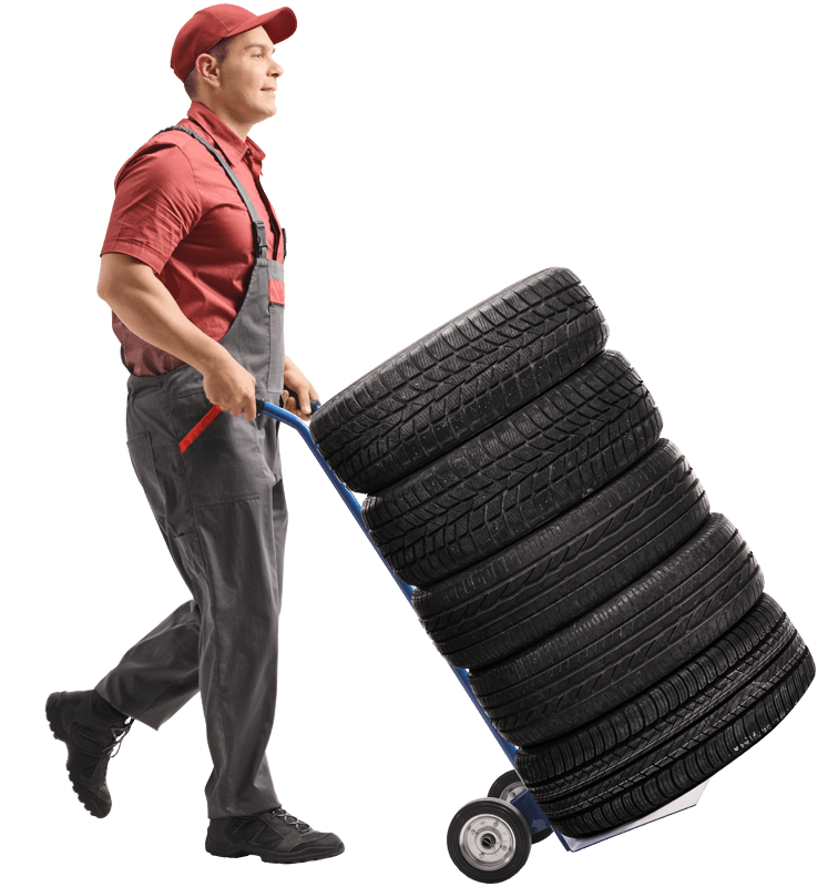 Homme qui transporte des pneus
