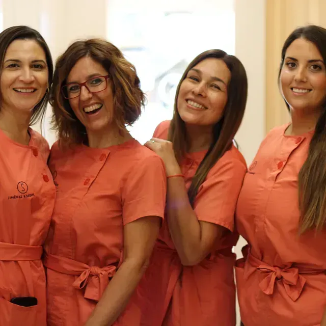 Un grupo de mujeres con uniformes rosas posan para una fotografía.