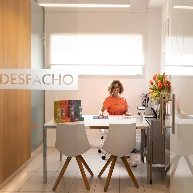 Una mujer está sentada en un escritorio en una oficina.