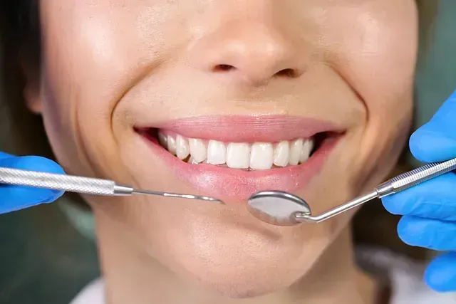 Una mujer está siendo examinada por un dentista.