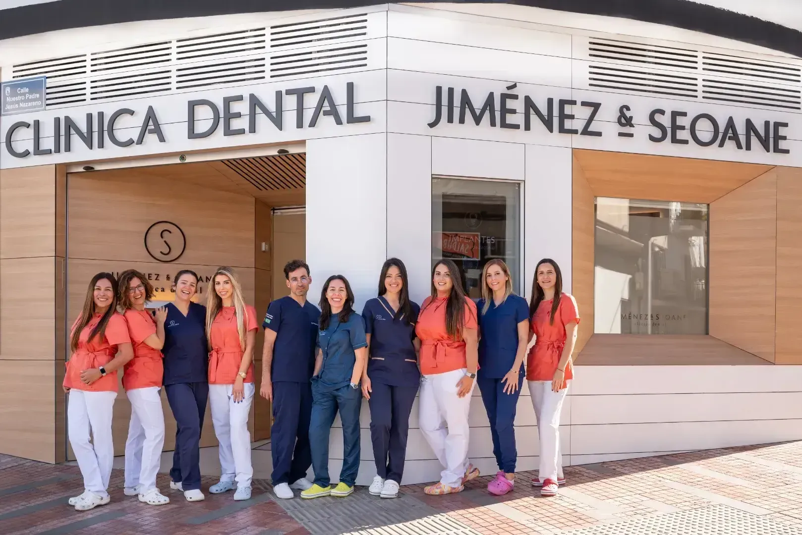 Un grupo de mujeres posa para una fotografía frente a un consultorio dental.