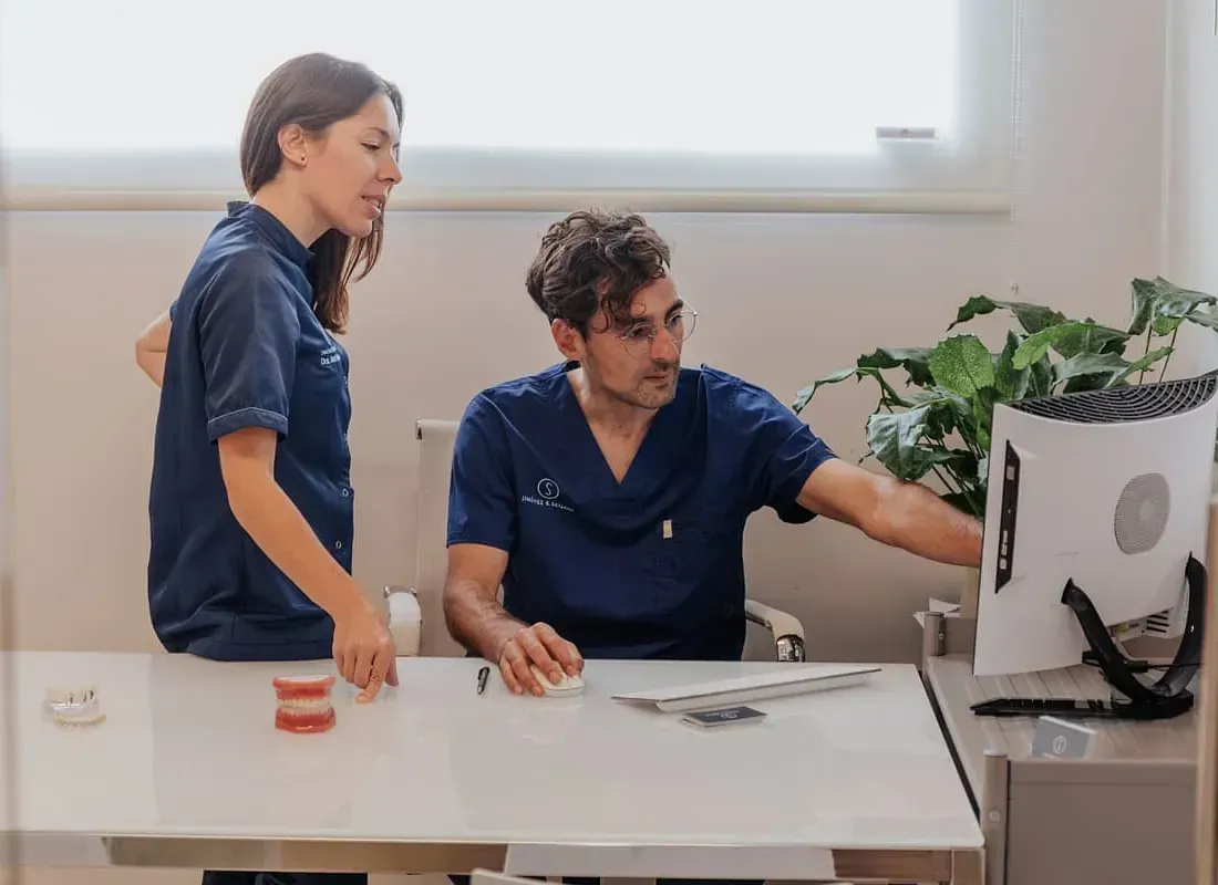 Un hombre y una mujer están mirando una pantalla de computadora.