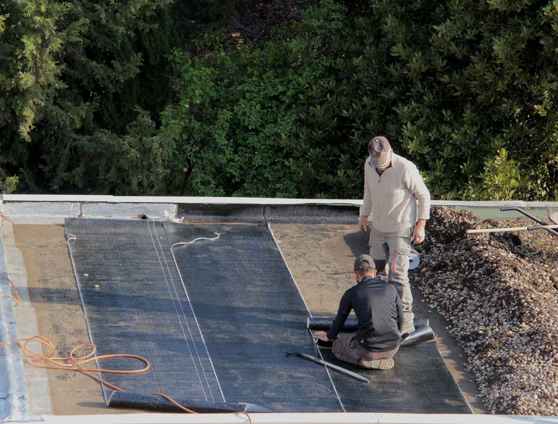 Deux ouvriers pendant la réfection d'un toit plat