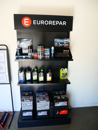 Rayonnage Eurorepar pour pièces automobiles, présentant des bidons d'huile et des produits d'entretien automobile dans un magasin.