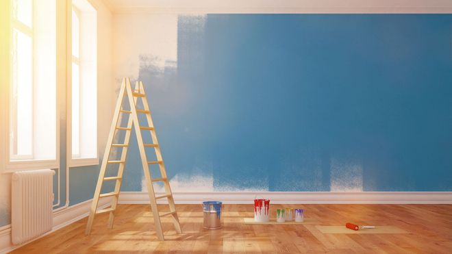 Ein leerer Raum mit einer blauen Wand, die gestrichen wird.
