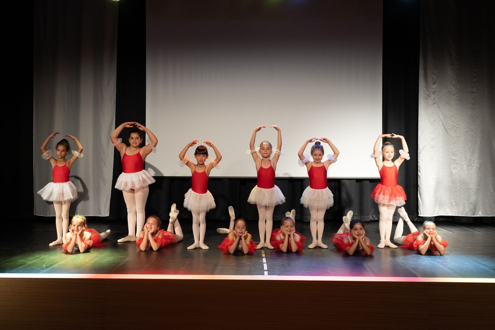 Kindergruppe in roten Ballett-Kostümen auf der Bühne in Herzform