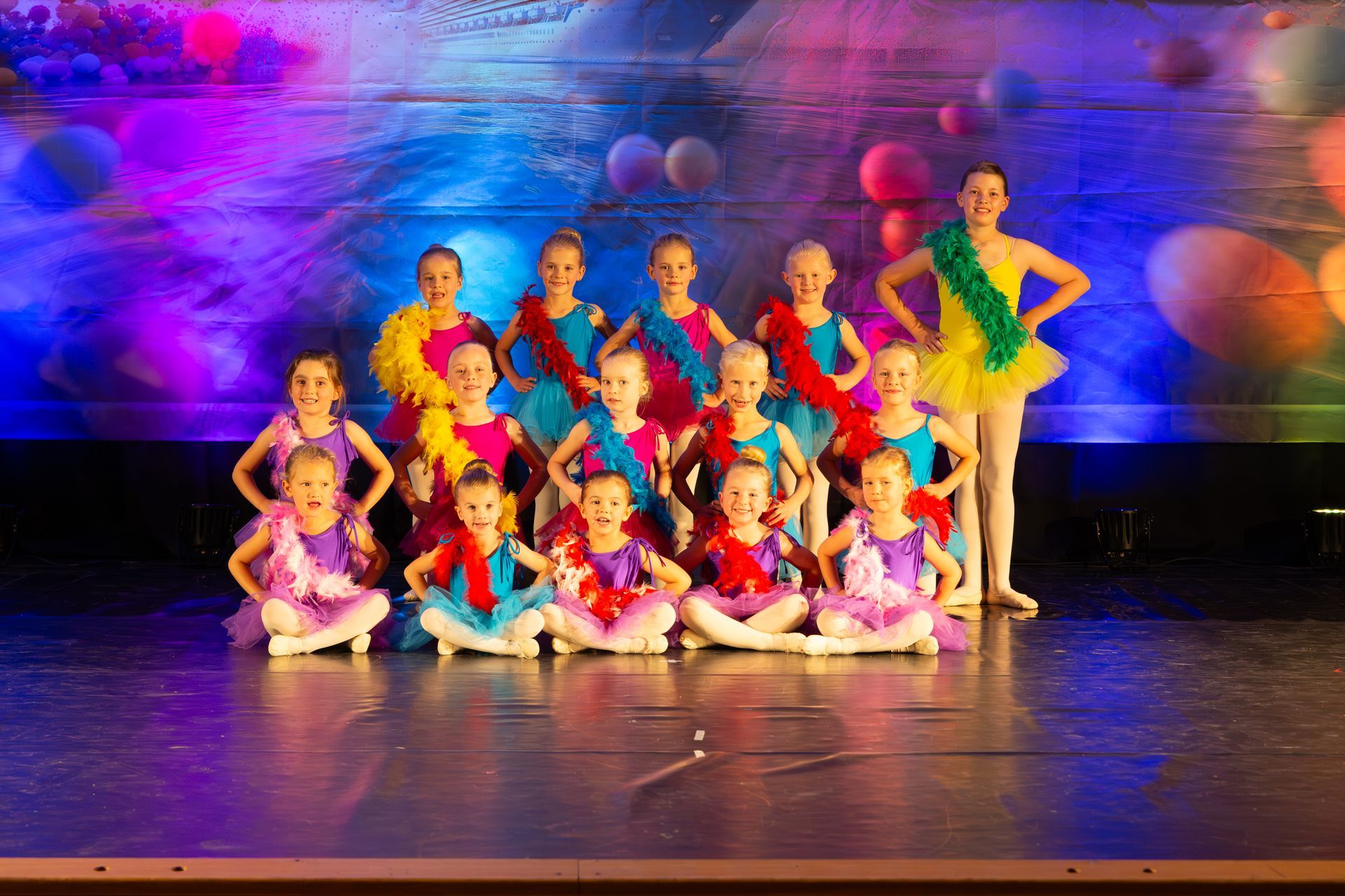 Tanzgruppe in Batik-T-Shirts posiert auf der Bühne