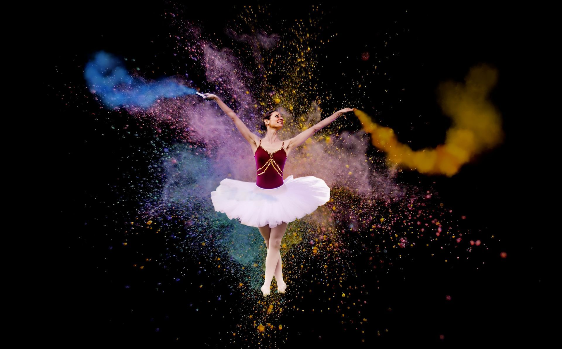 Ballerina springt durch farbige Pulverwolke