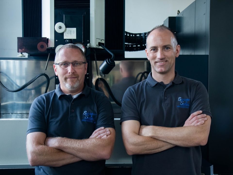 In einer Fabrik schneidet eine Maschine ein Stück Metall.