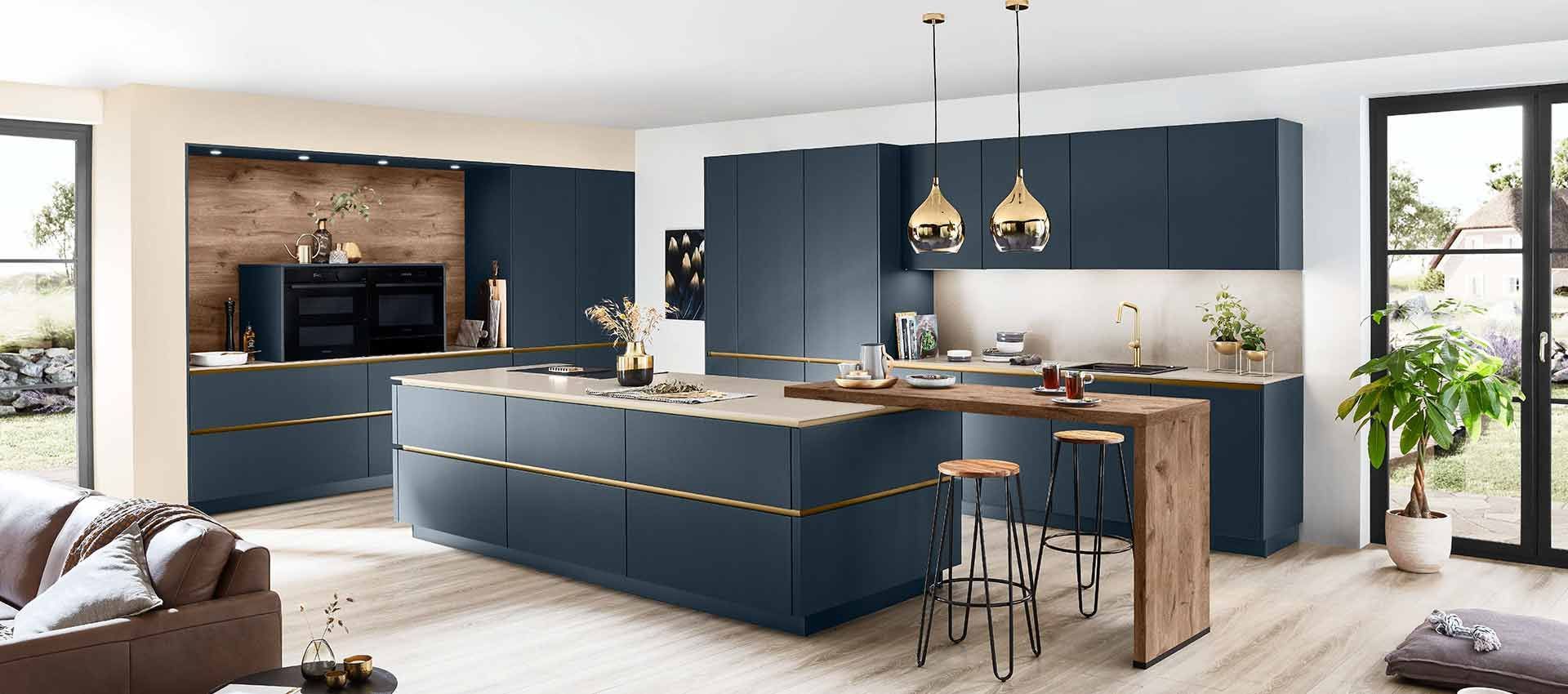 Moderne, offene Küche mit marineblauen Schränken, Holzelementen, Pendelleuchten und einer großen Kochinsel