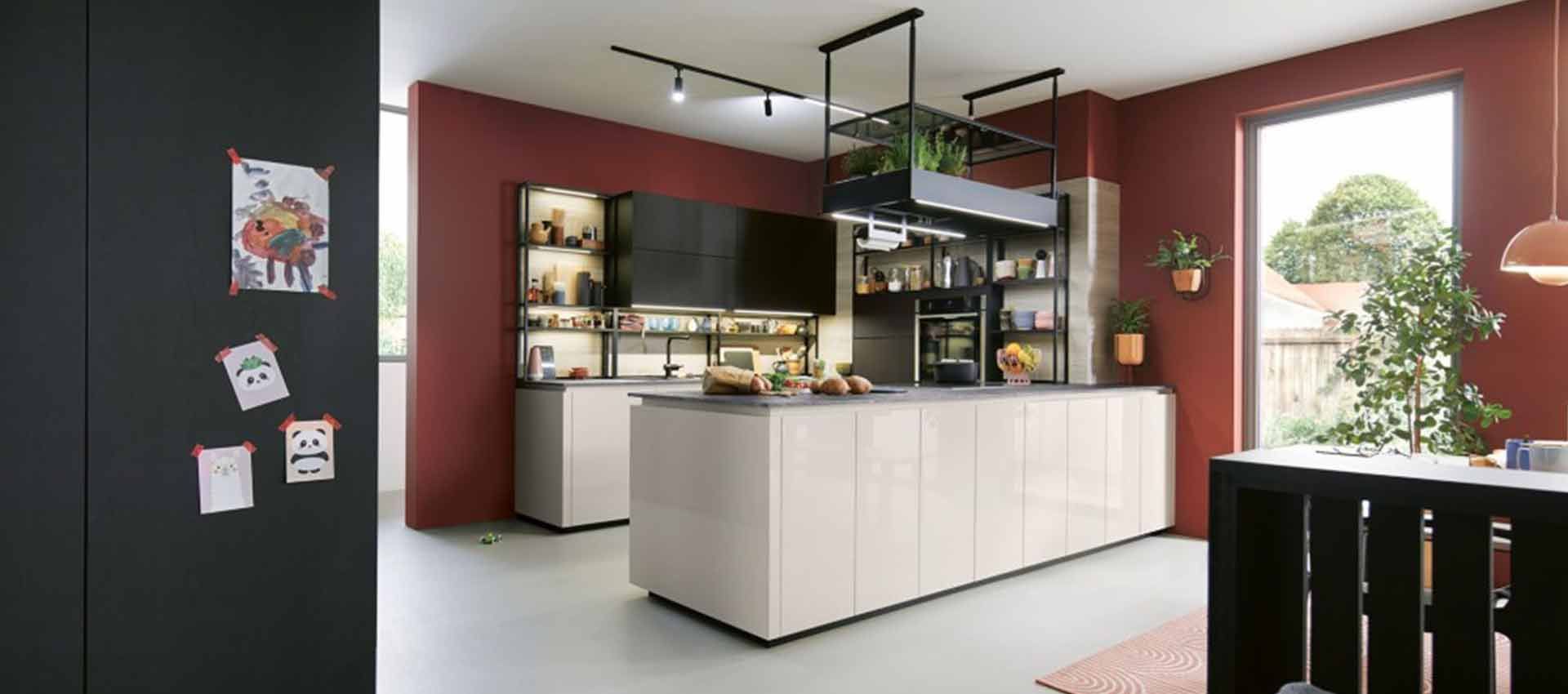 Moderne Küche mit weißer Kochinsel, dunklen Schränken, roten Wänden und einer Glastür zu einer Terrasse im Freien