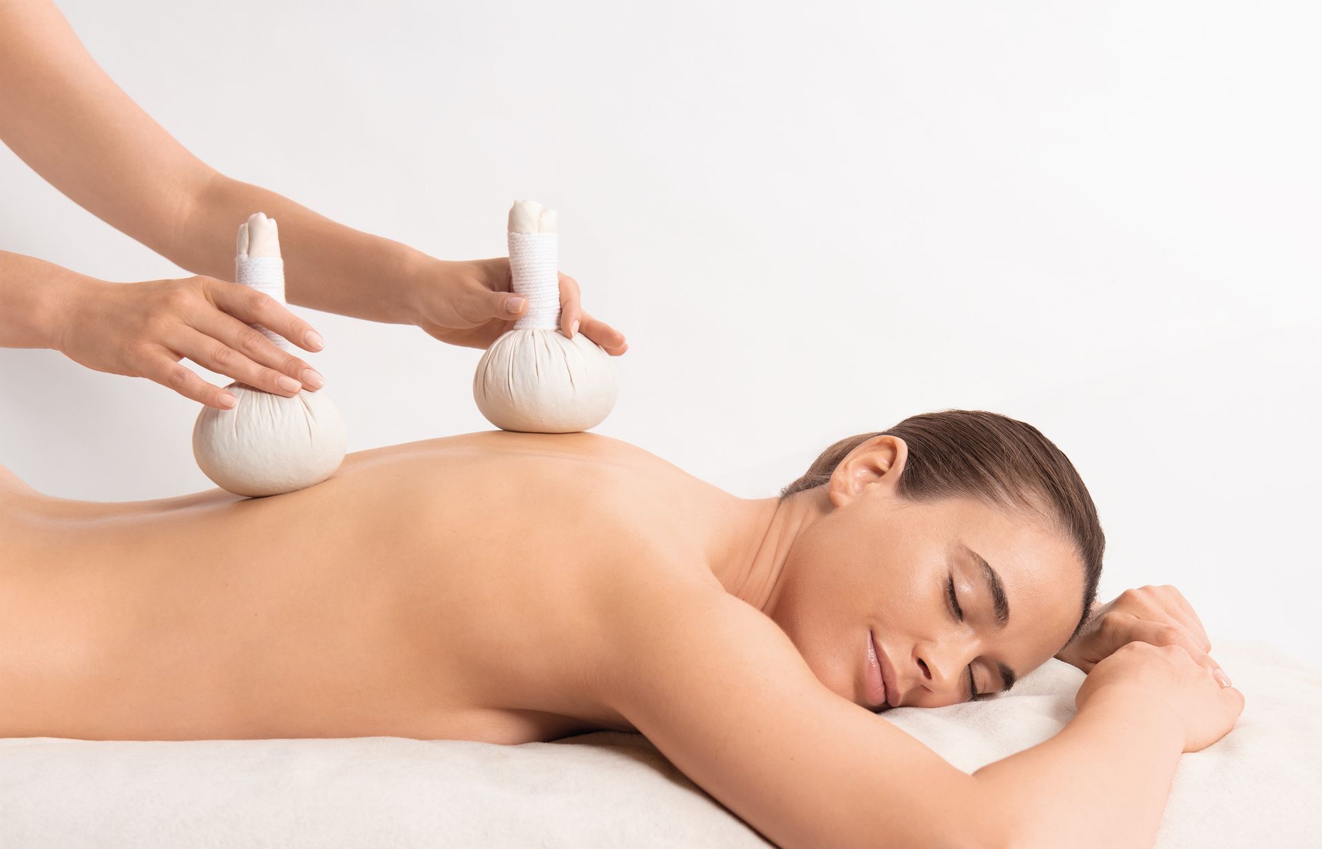 Massage aux pierres chaudes dans un spa, sur une personne allongée sur le ventre sur une table