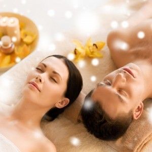 Deux personnessur des tables de spa, enveloppées de servietteS, dans un cadre floral apaisant et lumineux