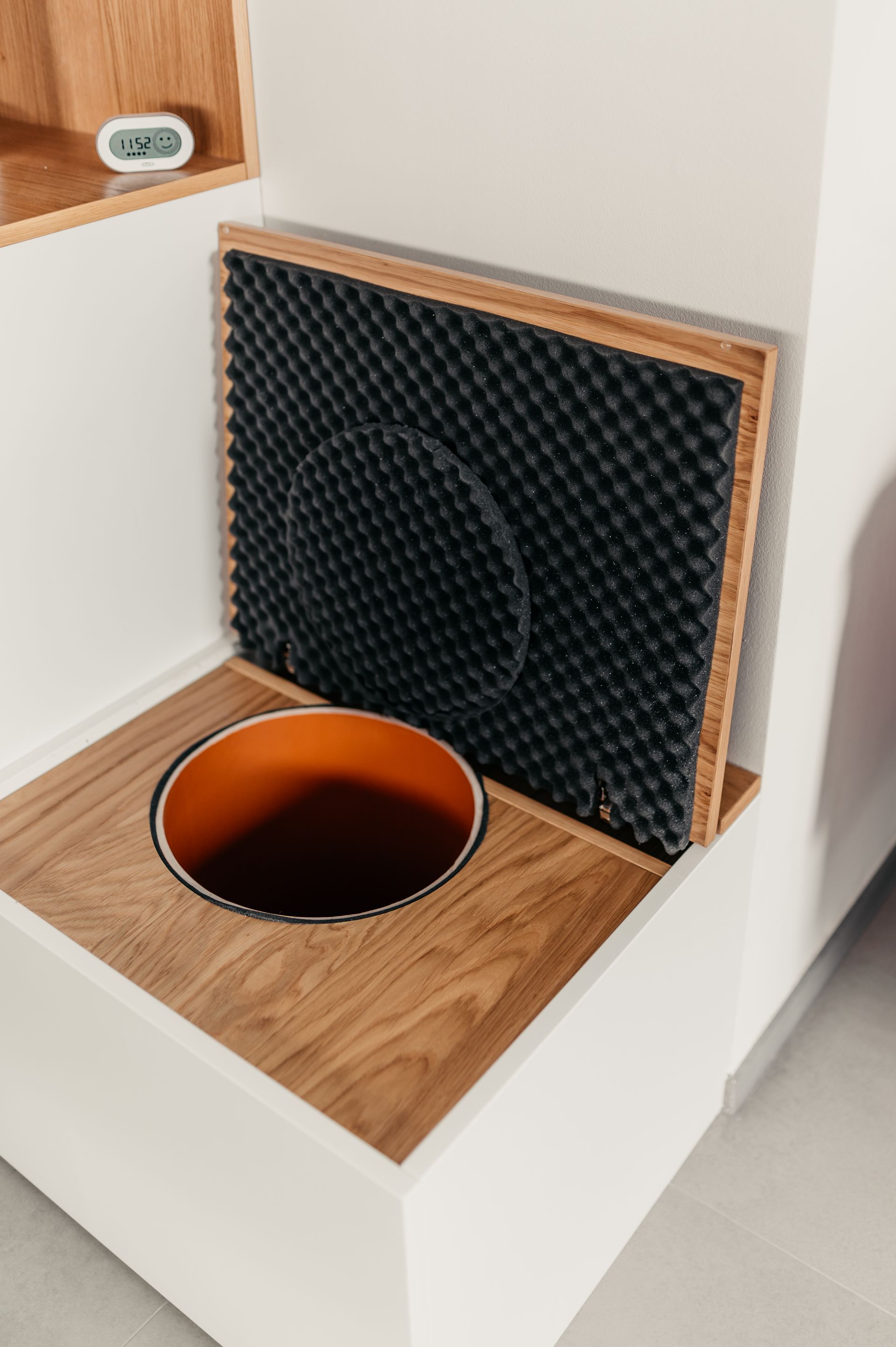 Offene Komposttoilette mit Holzrahmen und Schalldämmung.