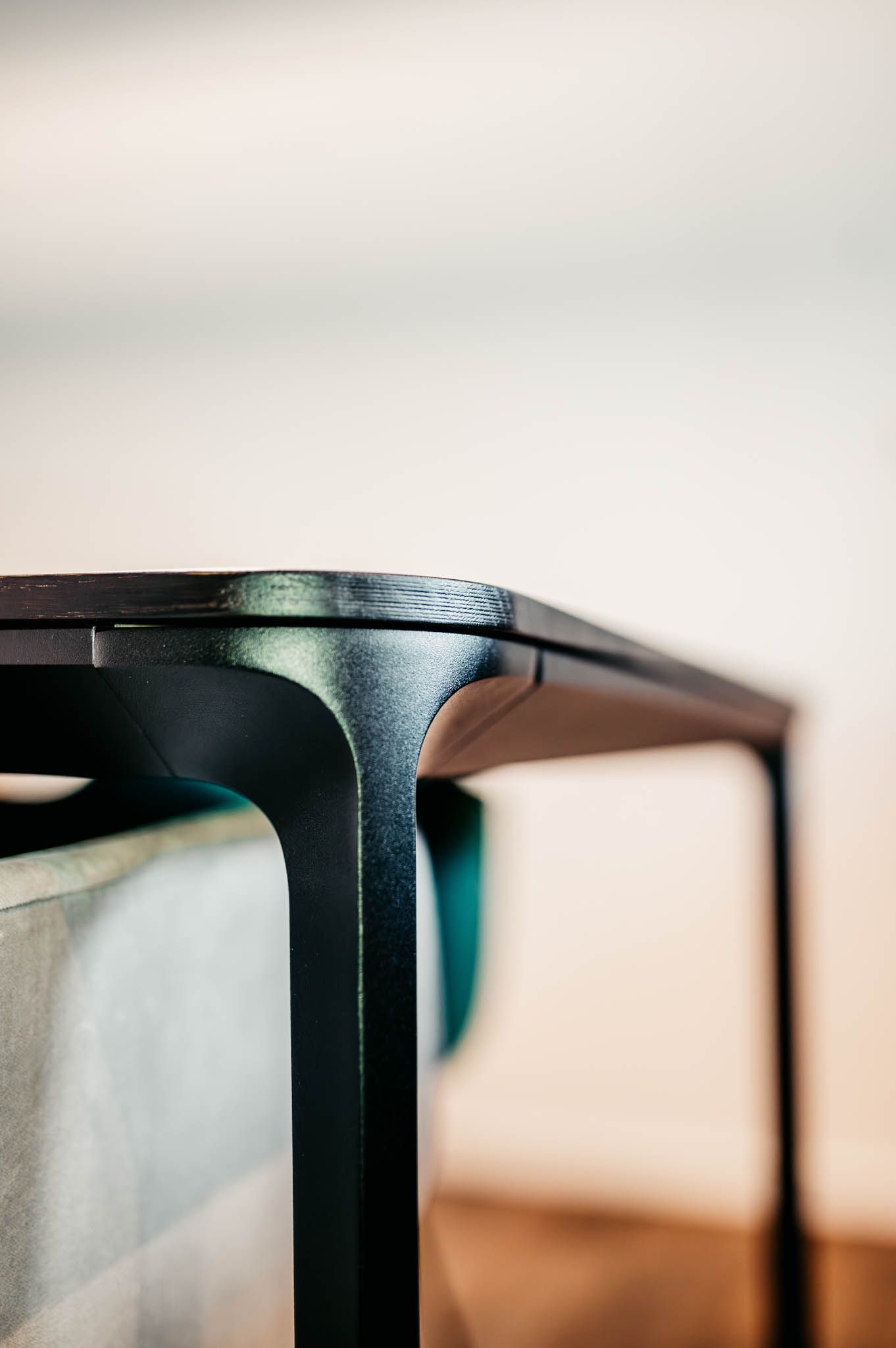 Schwarze Tischecke mit geschwungenem Bein in einem Raum.