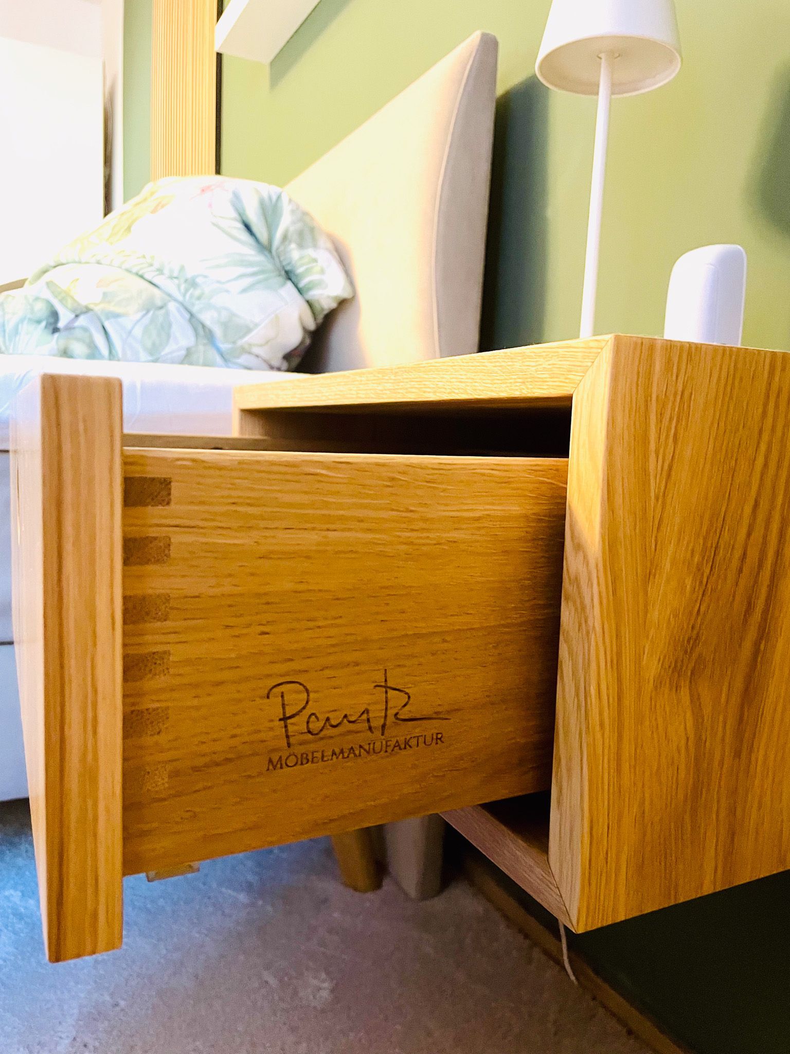 Die hölzerne Nachttischschublade ist geöffnet und gibt den Blick auf die Schwalbenschwanzverbindungen und die Signatur „Parnell“ frei.